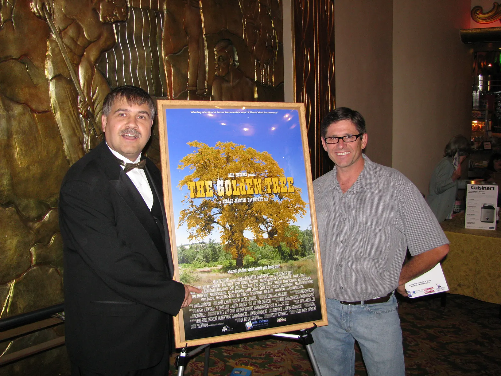 The director standing with Bill Bettencourt next to the poster for THE GOLdEN TREE