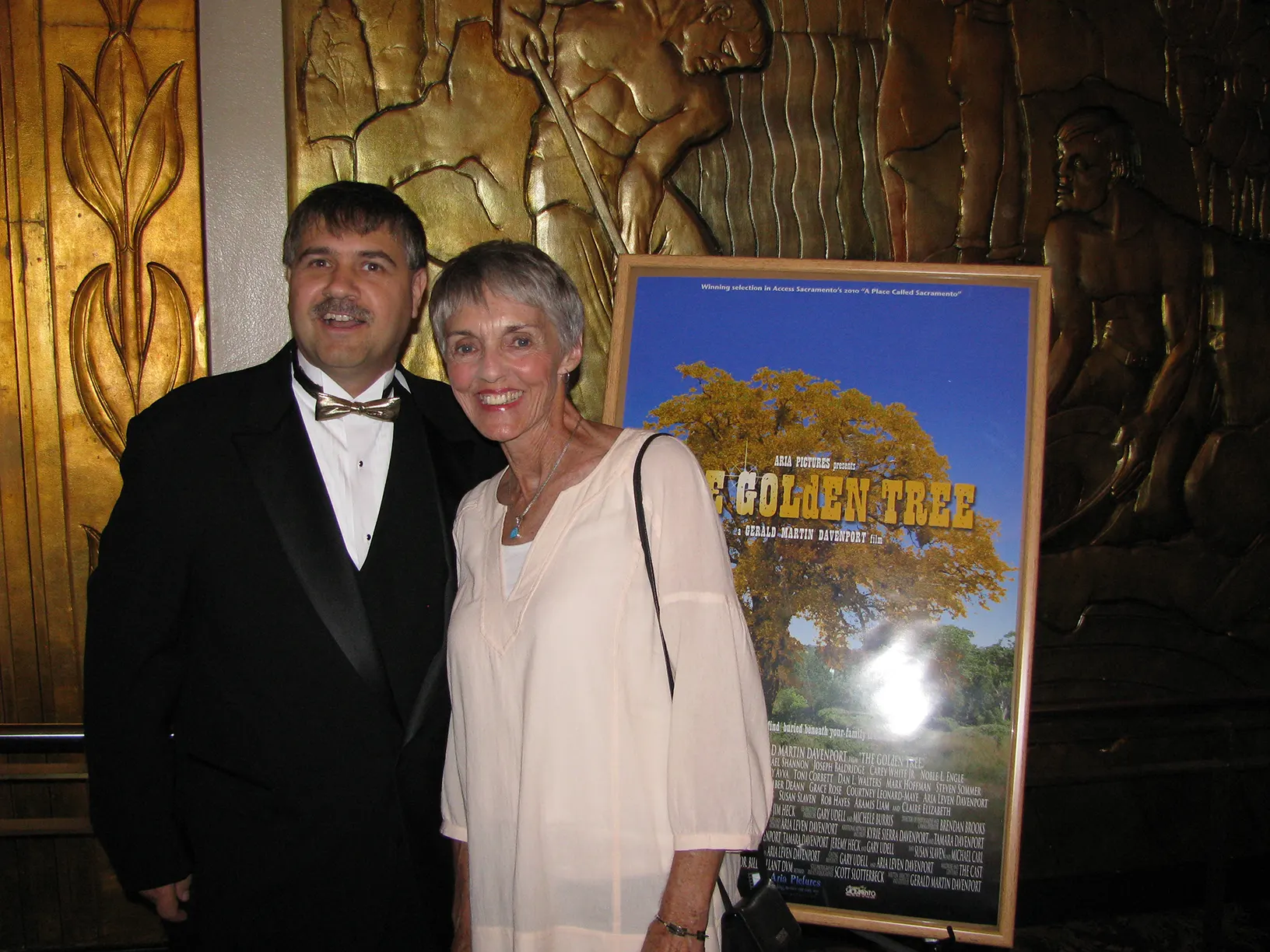 The director standing with Toni Corbett next to the poster for THE GOLdEN TREE - Access Sacramento- A Place Called Sacramento Film Screening at the Crest Theater in Sacramento, California.