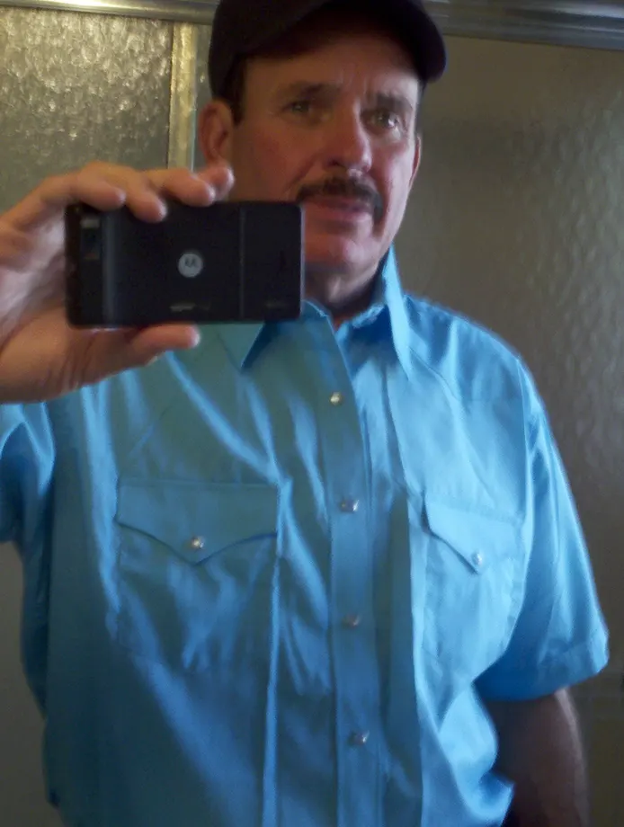the WATERING hole (2011) Rob Tillitz Wardrobe Light Blue Shirt with ball cap.