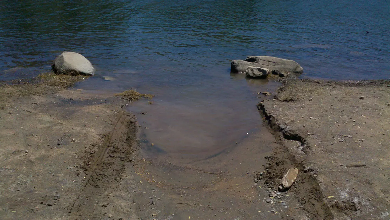Donton's Point on Folsom Lake with tire tracks going into the lake.